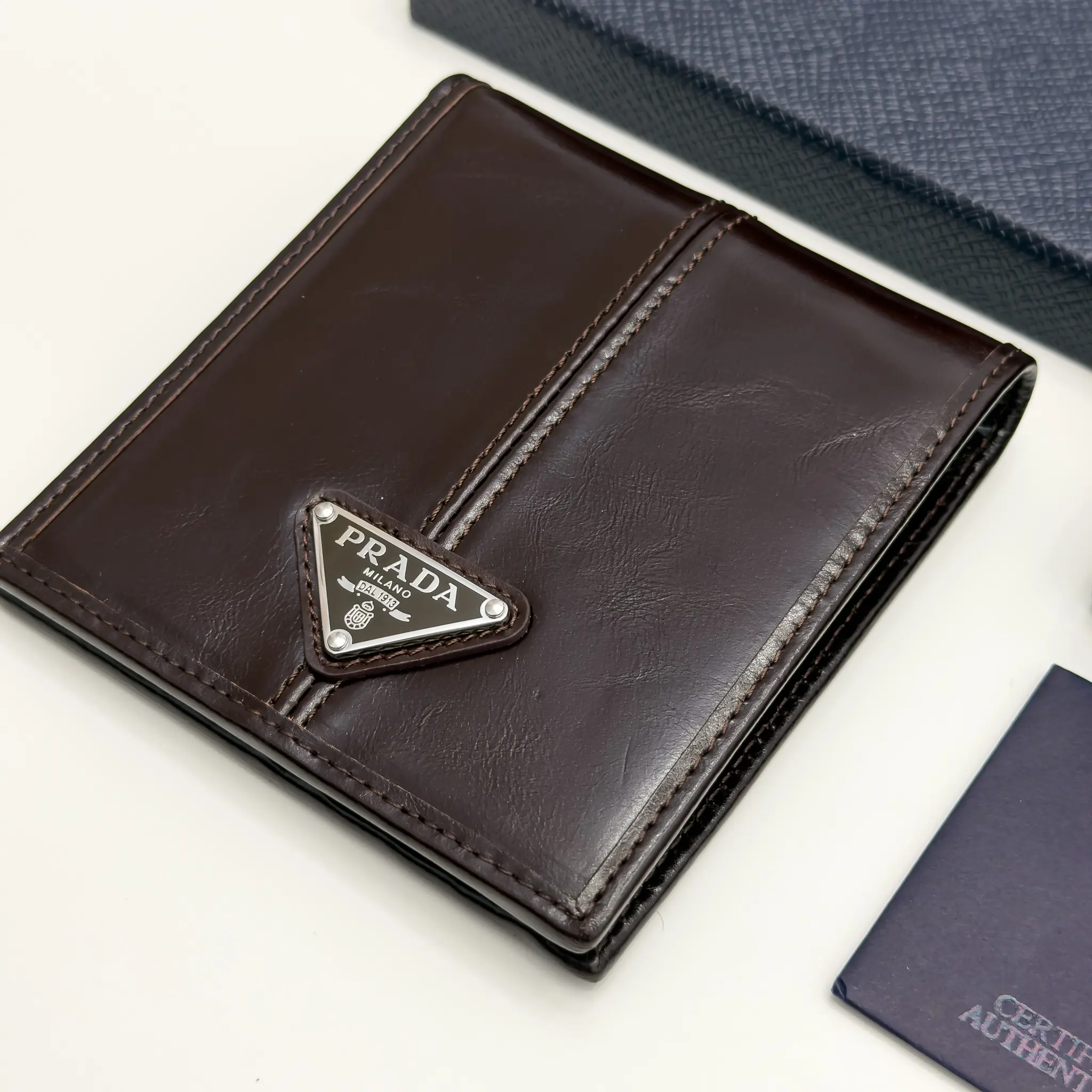 Prada dark brown calfskin bifold wallet with enameled triangle logo